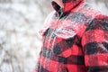 Snowy winter background with man in red plaid jacket