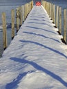 Snowy winter dock with pier shadows Royalty Free Stock Photo