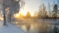 Snowy winter forest with shrubs and birch trees on the banks of the river with fog, Russia, the Urals, January