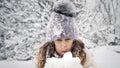 snowy winter fun. blowing snow. Happy, cutie, pretty, little girl, dressed in warm winter clothes, is blowing snow from Royalty Free Stock Photo