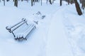 Snowy winter park ordinary outdoor view of January, slightly trail path way, wooden bench, nobody Royalty Free Stock Photo