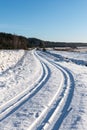 Snowy winter road with tire markings Royalty Free Stock Photo