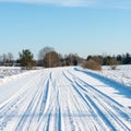 Snowy winter road with tire markings Royalty Free Stock Photo