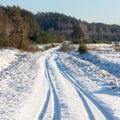 Snowy winter road with tire markings Royalty Free Stock Photo