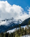 Snowy winter mountains peaks with green forest trees at sunny day Royalty Free Stock Photo