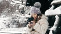 snowy winter selfie. cutie girl, dressed in warm winter clothes, fully covered with snowflakes, is sitting on bench and