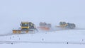 Snowy winter - three big snow removing trucks removes snow from the path on the way Royalty Free Stock Photo
