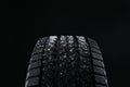 Snowy winter tire on black background, closeup Royalty Free Stock Photo