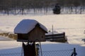 Snowy wooden bird feeder in winter garden rural scene