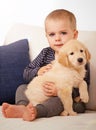 Snuggling his way into his heart. An adorable little boy with his puppy at home. Royalty Free Stock Photo