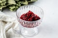 Soaked lingonberries in a transparent vase on a white background
