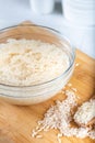 Soaked rice, grain, cloudy liquid water in glass bowl on wooden background Royalty Free Stock Photo