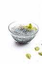 Soaked sweet basil or tukhmaria or falooda seeds or sabja seeds in a bowl with raw sweet basil seed isolated on white with a mint