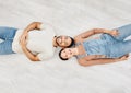 Soaking in the moment. High angle shot of a young couple lying on the floor while moving house. Royalty Free Stock Photo