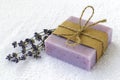 Soap bar with dry aromatic lavender flowers. Purple handmade soap on a white terry cotton towel. Natural toiletries and hygiene