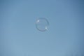 Soap bubble flies away in a cloudless sky