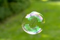 Soap Bubble isolated on green summer background. Kids fun activity. Royalty Free Stock Photo