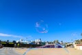 A soap bubble in the sky with gorgeous clear blue sky and hotels and restaurants on the pier at Santa Monica Beach