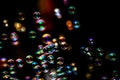 Soap bubbles from the bubble blower in dark or black background. Royalty Free Stock Photo