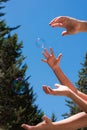 Soap bubbles in hands against a blue sky Royalty Free Stock Photo