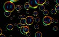 Soap bubbles isolated on black background. Rainbow soap bubble. Bright green and orande colors. Royalty Free Stock Photo