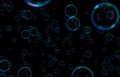 Soap bubbles isolated on black background. Rainbow soap bubble. Bright green and orande colors. Royalty Free Stock Photo