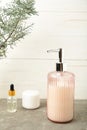 Soap dispenser with bath accessories on light background