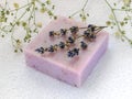 Soap with dry aromatic lavender flowers. Purple handmade soap bar on a white terry cotton towel. Natural toiletries and hygiene Royalty Free Stock Photo