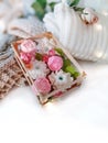 Soap floweres in box, knitted clothing, rose and lights on white background. Royalty Free Stock Photo