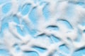 Soap foam on blue surface. Shampoo, cleanser, shower gel bubbles.  Bath hygiene background Royalty Free Stock Photo