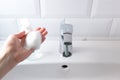 Soap foam on female hand, close-up. Washing hands over the sink in the bathroom, indoors. Concept healthcare Royalty Free Stock Photo