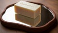 Soap is a light cream color and rests on a mirror with a brown Royalty Free Stock Photo