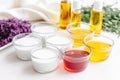 soap making ingredients: oil, lye, herbs, and colorants on a white surface