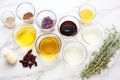 soap making ingredients: oil, lye, herbs, and colorants on a white surface