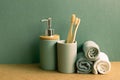 Soap, shampoo bottle and cotton towels, toothbrush on brown shelf. green wall background. bathroom interior Royalty Free Stock Photo