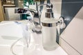 Soap and shampoo dispensers near Ceramic Water tap sink with faucet in expensive loft bathroom Royalty Free Stock Photo