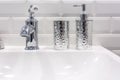 Soap and shampoo dispensers near Ceramic Water tap sink with faucet in expensive loft bathroom Royalty Free Stock Photo