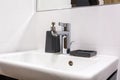 Soap and shampoo dispensers near Ceramic Water tap sink with faucet in expensive loft bathroom Royalty Free Stock Photo