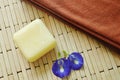 Soap and towel with blue pea violet flower on bamboo mat Royalty Free Stock Photo