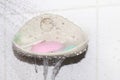 Soap, water splash and soap bar on dish at wall, soap cubes used selective focus