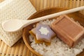 Soap, wisp,sea salt in a wooden bowl cleansers on the background