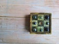 Soapstone solitaire board with green dots. On a wooden table, top view .