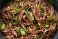 Soba noodles, buckwheat on a black bowl, with spring onion and sesame seeds. Traditional Japanese food. Royalty Free Stock Photo