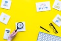 Socail media icons on work desk of marketing expert. Digital promotion of goods and services. Yellow background top view