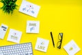 Socail media icons on work desk of marketing expert. Digital promotion of goods and services. Yellow background top view