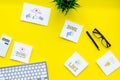 Socail media icons on work desk of marketing expert. Digital promotion of goods and services. Yellow background top view