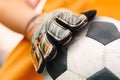 Soccer background detail image. Close up on football ball and sports goalie gloves