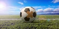 Soccer ball with a band aid on green grass field, blue sky background. 3d illustration Royalty Free Stock Photo