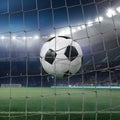 Soccer ball bends net inside stadium, capturing the excitement of scoring goals in sports