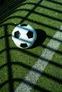 Soccer ball black and white on artificial ground ground with shadows stripes, over the line Royalty Free Stock Photo